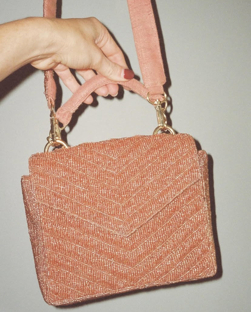 Close-up of the back of the Waves Never Cease bag showing the natural jute lining, gold hardware, and detachable beaded strap.