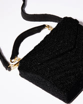 Close-up detail of the hand-dyed black glass beads and gold chain hardware on the Waves Never Cease event bag.