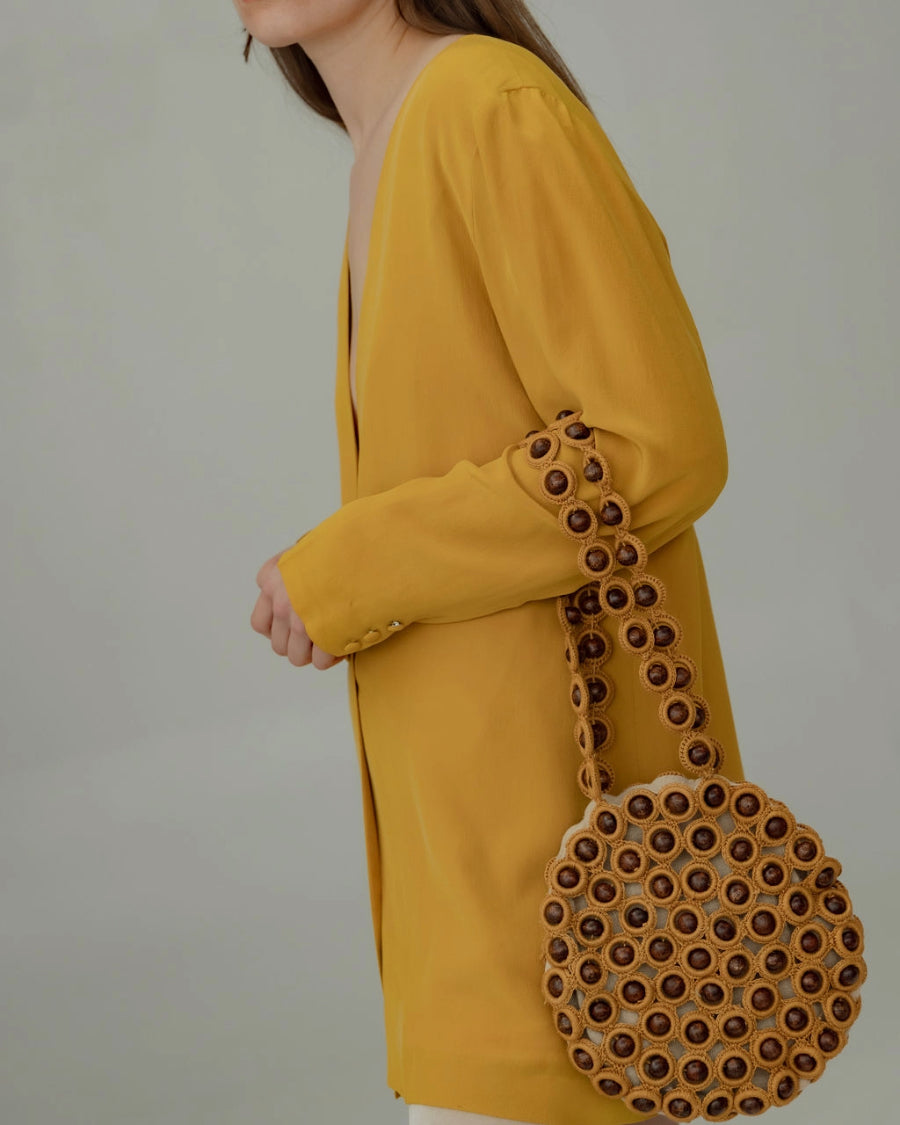 Model wearing the mustard yellow crochet bag over her shoulder, demonstrating the 30cm handle drop and comfortable fit.