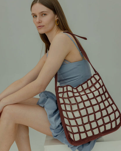 The Returning Form tote bag in a seated position, demonstrating its versatile design for travel, work, and intentional daily rotation.