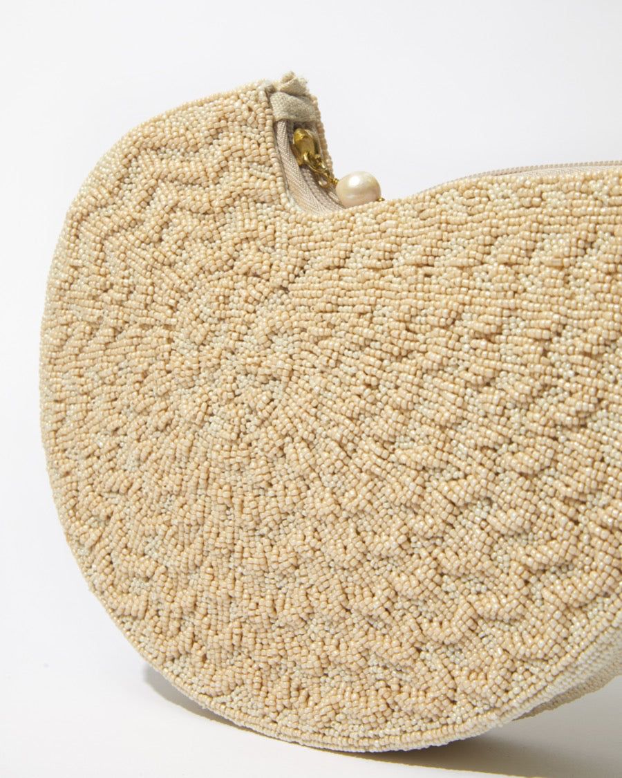 Extreme close-up of the Beyond Us clutch showcasing the artisanal hand-dyed glass beads and the tactile, embossed woven-style pattern.