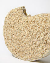 Extreme close-up of the Beyond Us clutch showcasing the artisanal hand-dyed glass beads and the tactile, embossed woven-style pattern.