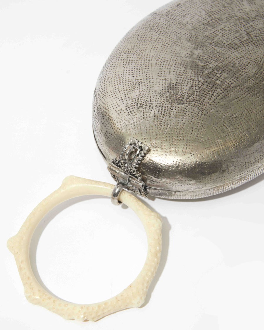 Close-up of the back of the Capacity for Presence bag, showcasing the organic hand-beaten texture of the silver brass and the detailed metal clasp.