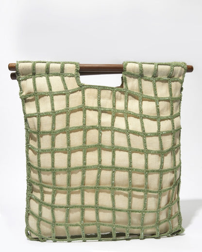 Straight-on view of the Entwined Tote in sage green, highlighting the meticulous hand-dyed glass bead and crochet craftsmanship.
