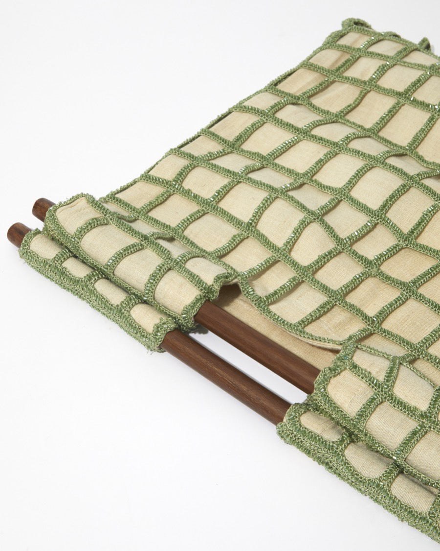 Close-up of the dark wooden bar handles and the delicate beaded crochet texture of the sage green Entwined Tote bag.