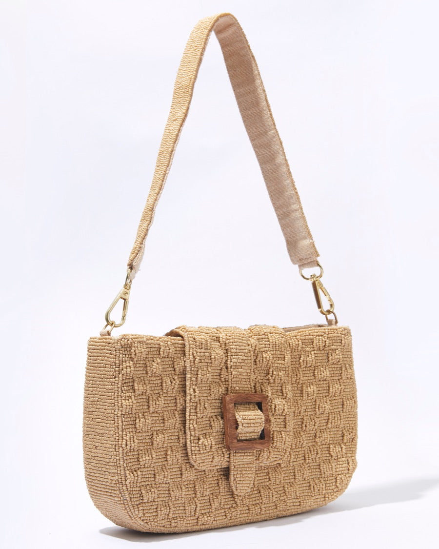 Three-quarter studio view of the Familiar Way beaded bag in tan, featuring a hand-beaded woven design and a rich wooden buckle.