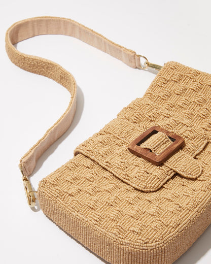 Close-up of the embossed woven beadwork and the natural wooden buckle interwoven into the top fold of the Familiar Way bag