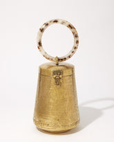 Front studio view of the Perception of Time gold brass bag, featuring a tapered hand-beaten metal body and a circular tortoiseshell resin handle.