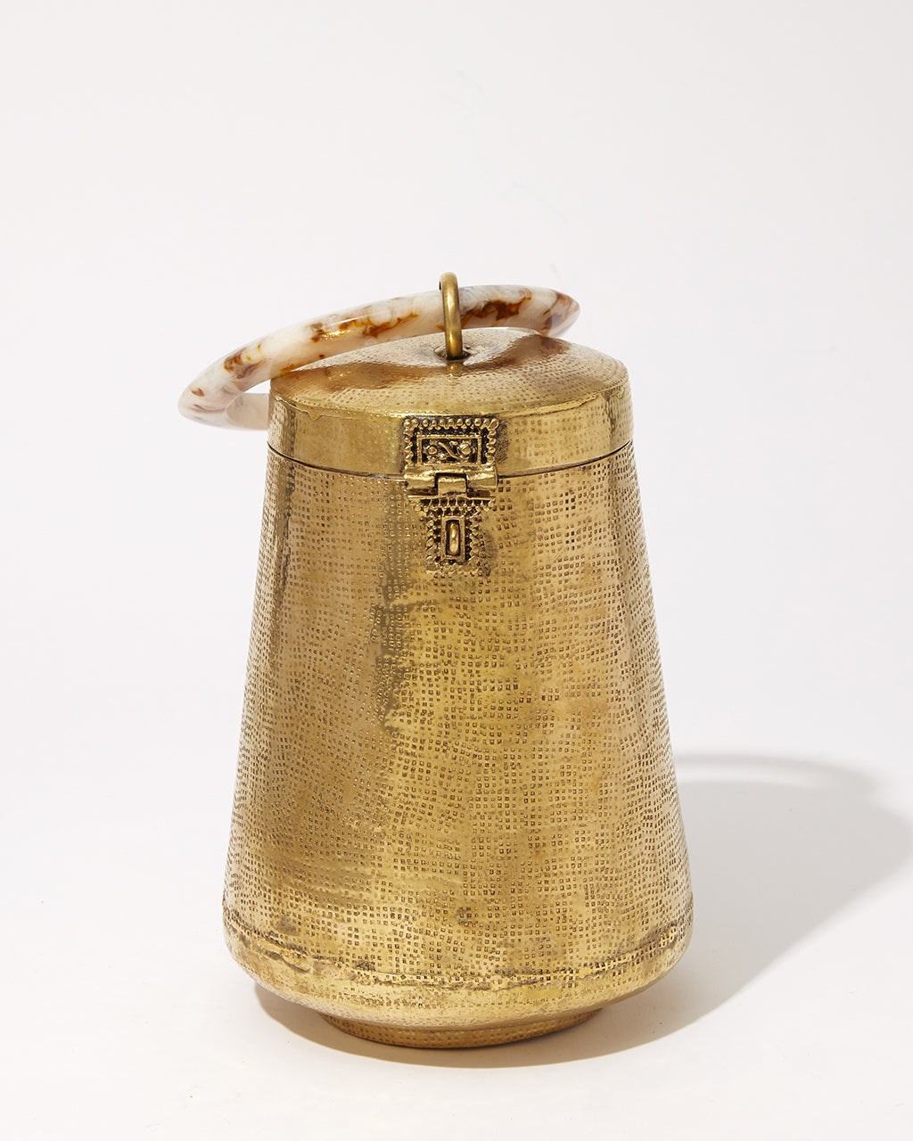 Top-down view of the Perception of Time bag showing the connection between the polished resin handle and the textured brass body.