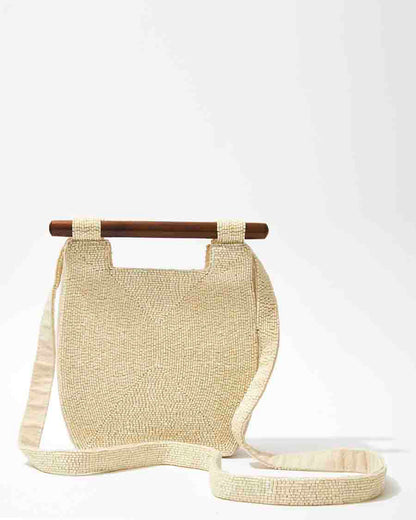 Front studio view of the Reach for Words white beaded bag featuring a sculptural silhouette and smooth dark wooden bar handles.