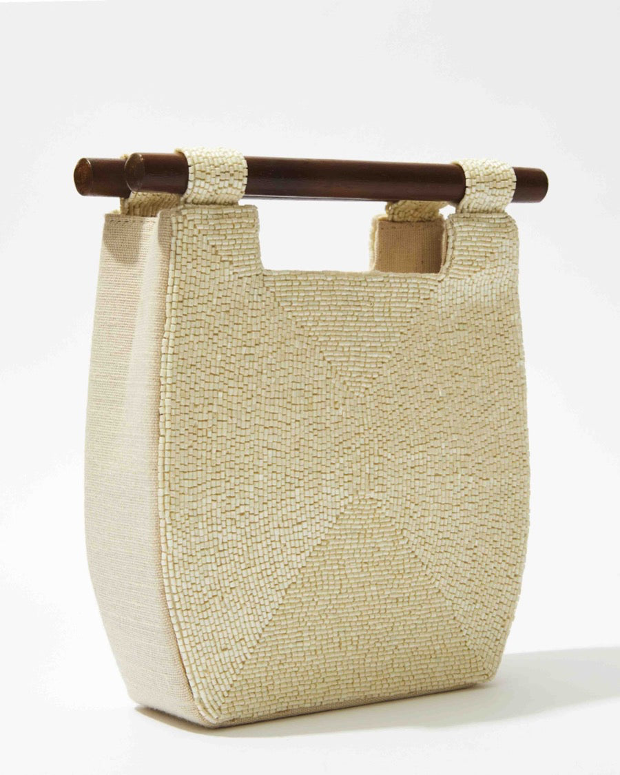 Side profile of the minimalist white beaded bag showcasing its structured 5cm depth and clean architectural lines.