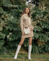 Model in a beige outfit carrying the white Reach for Words bag as a crossbody, showcasing the long detachable beaded strap.