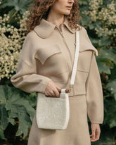 Close-up of a model wearing the white beaded bag over the shoulder, demonstrating its versatility and wearable design.