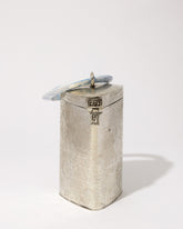 Three-quarter studio view of the Right Off The Edge brass handbag, featuring a unique triangular cylinder shape and blue marble resin handle.