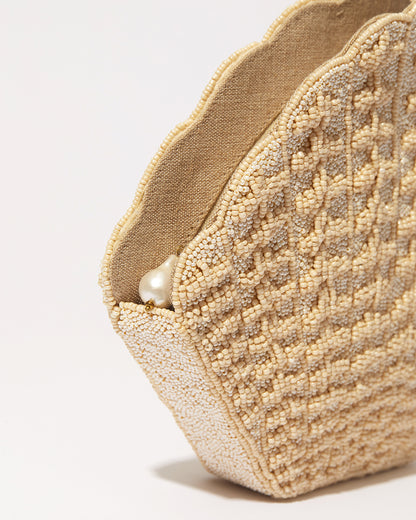 Close-up of the scalloped edge and pearl zipper detail on the champagne Stand Still beaded clutch.