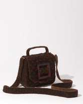 Three-quarter studio view of the Uncovered Layers rich brown beaded bag featuring a layered woven design and glossy resin buckle.