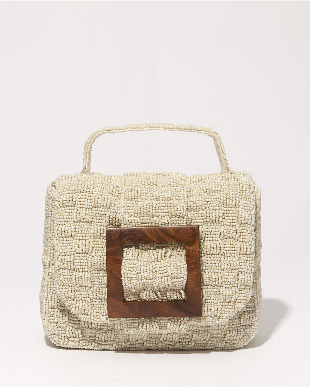 A straight-on studio shot of the white Uncovered Layers bag, emphasizing the contrast between the luminous glass beads and the dark wooden buckle.