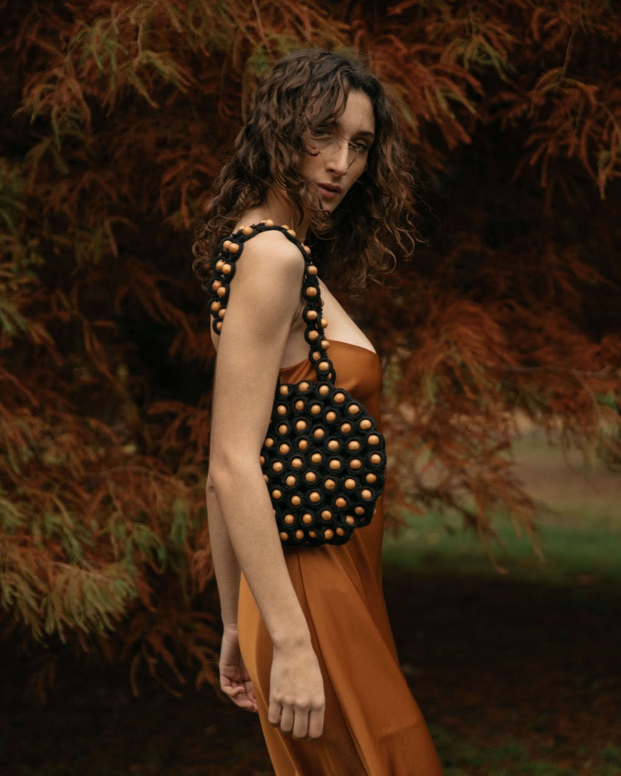 Model wearing an orange silk dress styling the &