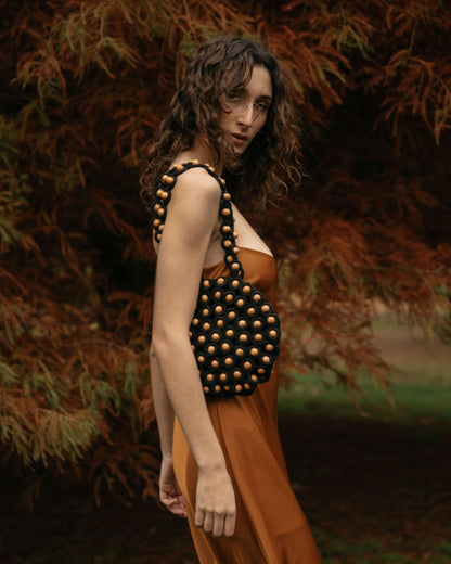 Model wearing an orange silk dress styling the &