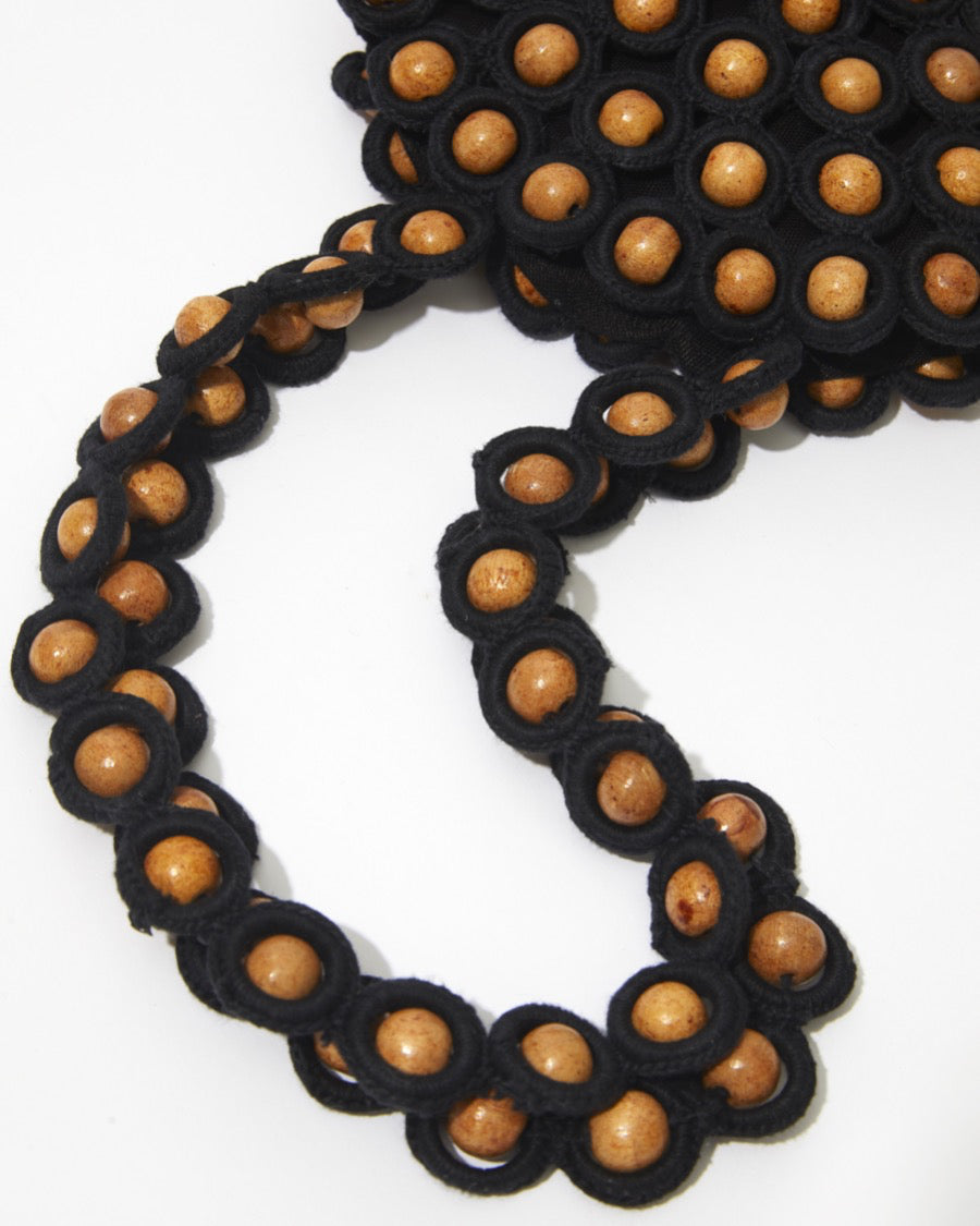 Close-up of the long crochet and wooden bead handles, designed for effortless shoulder or arm carry.